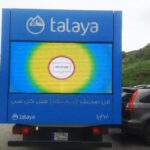 Talaya 2 Blue Talaya advertising panel on the back of a truck with a digital screen showing a circular rainbow color burst