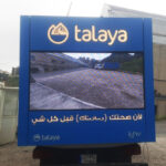 Talaya 4 Blue promotional truck back panel with Talaya logo and slogan; large display showing a road scene, Arabic text below the screen.